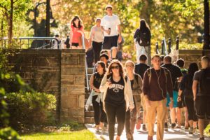 Students walking across campus on sunny day.