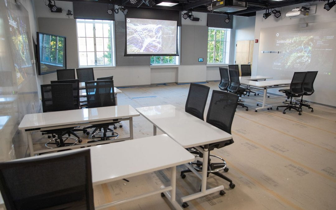 Tables in a work space with large white boards